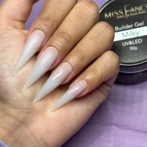 Builder Gel Milky från Miss Fancy - Builder Gel Milky från Miss Fancy ger en mjölkvit, naturlig finish till naglarna. Perfekt för att skapa långa, spetsiga eller mandelformade naglar med en glansig yta. Gelen härdas med UV/LED-lampa och passar dig som vill ha en clean och fräsch look.
