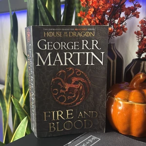 Fire and Blood - Upptäck den episka historien bakom House of the Dragon! Den här boken tar dig till Westeros blodiga förflutna, fylld av drakar, maktkamp och svek. Perfekt för dig som älskar fantasy, spänning och Game of Thrones-världen.