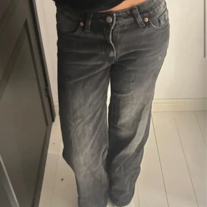 Grå wide jeans från Monki - Säljer ett par gråa jeans från Monki med breda ben och klassisk femficksdesign. Jeansen har låg midja och är tillverkade i ett mjukt denimtyg. Perfekta för dig som gillar en avslappnad och trendig look.