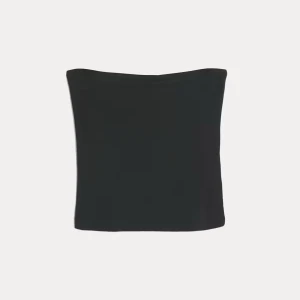 Svart tubetopp från Cubus - En svart tubetopp från Cubus i storlek XS. Toppen är axelbandslös och har en enkel, tight passform som sitter snyggt på kroppen. Perfekt att matcha med jeans eller kjol för en clean look. Aldrig använd bara testad. Helt slutsåld på hemsidan.