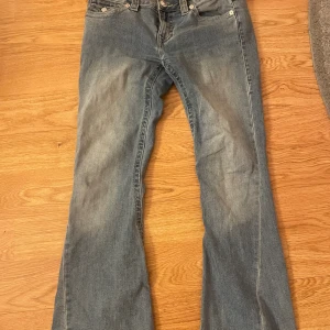 True Religion Joey Low Rise Flare Jeans -  W27 Snygga blå jeans från True Religion i modellen Joey Low Rise Flare. De har låg midja, utsvängda ben och klassiska detaljer med stora bakfickor och kontrastsömmar. Jeansen är gjorda i jeansmaterial. Pris kan diskuteras, inga defekter