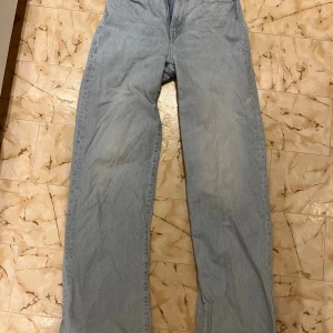 Ljusblå jeansbyxor från 157, XS - Ljusblå vida jeansbyxor från 157 i storlek XS. Klassisk femficksmodell med normal passform och hög midja. Jeansen är tillverkade i bomull och har en enkel, tidlös look med ljus tvätt och vida ben.