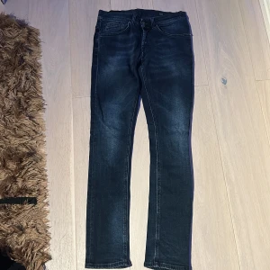 Dondup George jeans - Snygga mörkblå Dondup George jeans med klassisk femficksdesign och diskret tvättade detaljer. Jeansen har smal passform hela vägen ner och är tillverkade i stretchigt denim för en bekväm känsla. Perfekta för dig som gillar en tight look.