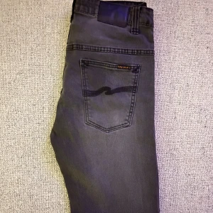 Grå nudie jeans -  Märke: Nudie jeans (Thin finn) 📏 Storlek: W32 L32 ✨ Skick: Mycket gott skick / Nästan som nya 🎯 Perfekta både till vardags och när du vill klä upp dig lite extra 📦 Snabb leverans – skickas samma dag! 💌 Har du frågor? Hör gärna av dig – svarar snabbt!