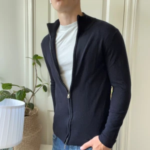 Oscar Jacobsson Ariel full zip - Oscar Jacobsson Ariel full zip svart, storlek L, gjord av 100% virgin wool. Inga defekter, modellen är 180,75 kg sitter bra på honom🫶☺️