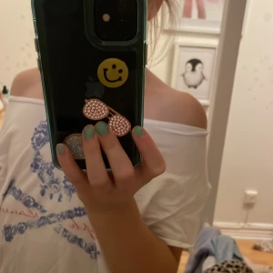 Vit offshoulder topp från Polo Ralph Lauren - Säljer en vit offshoulder topp från Polo Ralph Lauren i storlek M. Toppen har korta ärmar och ett blått tryck framtill med text och mönster. Materialet är mjukt och lätt bomull, perfekt för varma dagar. Snygg och enkel att styla med jeans eller kjol.