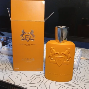 Parfums de Marly Althaïr EdP 125ml - Exklusiv parfym från Parfums de Marly, Althaïr EdP 125ml. Flaskan är matt orange med silverfärgad kork och har ett upphöjt emblem med två hästar. Doften är varm, amberaktig med inslag av trä och vanilj. Lyxig och modern design, perfekt för dig som gillar unika dofter. Säljer den för jag bara behöver pengar o fick den i födelsedagspresent. Hör av er vid frågor! Pris kan diskuteras.