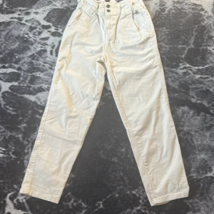  Vita jeans med resår i midjan  -  Vita snygga Jeans byxor med två knappar, resår i midjan och halvösa.