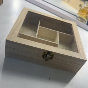Trälåda  - Snygg och stilren trälåda med glaslock och flera fack, perfekt för att organisera ringar, armband, halsband eller örhängen. Lådan är ljus i trä och har ett klassiskt metallspänne framtill.