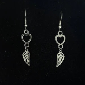 Silvriga örhängen med hjärta och vinge - Handgjorda och unika silverörhängen 🤩 Öronhängerna är nickelfria och silverpläterade i kirurgiskt stål, resterande av örhänget är i rostfritt stål (ej silverpläterat) 💕🙏 4 cm långa. Alla köp görs via ”KÖP NU” knappen.  💐