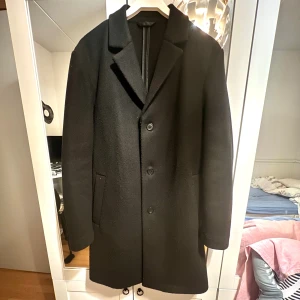 Svart Kappa från HM - Säljer denna fina och fräscha kappan då den ej passar längre, använd sparsamt och är som ny. Riktigt bra nu inför vintern och håller värmen fantastiskt bra. Storlek M men kan även sitta som en större s med lager under. Nypris 700kr, Vid snabb affär så kan priset diskuteras 😊