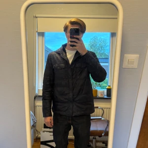 Quiltad blå jacka från Oscar Jacobson - Sorry för att min spegel är tvärsmutsig! Säljer en quiltad mörkblå jacka från Oscar Jacobson. Riktigt fin i storlek 50 (M). Den passar perfekt till hösten och våren eller lite varmare väder under vintern. Skön passform och varm. Den har ett litet hål på insidan av jackan men ingenting på utsidan eller i någon ficka liksom, den går att laga väldigt lätt. Nypris 3000kr. Hör av vid frågor😊