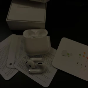 AirPods gen 4 - Apple AirPods Pro med originalförpackning och tillbehör. Trådlösa hörlurar med aktiv brusreducering och laddningsetui. Produkten ser ut att vara i gott skick med endast mindre tecken på normalt bruk. Perfekt för musik, samtal och träning.
