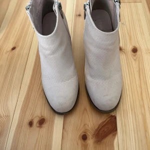 Beige/rosa boots  - Snygga beige/rosa boots med ormskinnsmönstrad yta, grov klack och dragkedja på sidan. Skorna har rund tå.