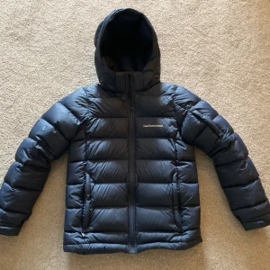 Peak Performance Dun jacka  - Jag säljer denna feta jacka från Peak Perfomance. Den är marin blå i storleken 160 men passar absolut folk med XS i storlek. Nypris ligger på uungefär 2500 och jag säljer den för 1500. Jackan är i väldigt bra skick och det finns inga skador eller hål. 