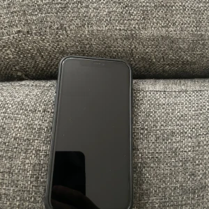 iPhone 11 - Snygg svart iPhone 11 i gott skick. Dubbelkamera med rosa dekorringar, inga synliga repor eller sprickor på skärm eller baksida. Alla knappar och portar ser hela ut. Perfekt för dig som vill ha en pålitlig och stilren mobil med bra kamera.