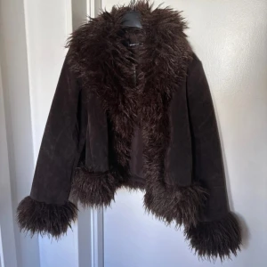 Brun pälsjacka från Gina Tricot XS - Säljer en mörkbrun pälsjacka från Gina Tricot i storlek XS. Jackan har fejkpäls runt krage, ärmslut och nederkant samt är gjord i mjuk mockaimitation. Den är helt slutsåld i butik och online. Säljer den för samma pris jag köpte för eftersom den är ny med lappar kvar.