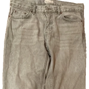 Gråa wide jeans från Perfect Jeans - Gråa jeans från Perfect Jeans i storlek 38. Modellen har raka, vida ben och klassisk femficksdesign. Jeansen är tillverkade i ett mjukt denimtyg och har bälteshällor samt knappstängning framtill. Perfekta för en avslappnad och trendig look.