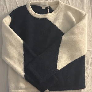 Svartvit stickad tröja från Gina Tricot - Säljer en snygg stickad tröja från Gina Tricot i svart och vitt med coolt diagonalblockmönster. Tröjan har rund halsringning och långa ärmar. Perfekt för dig som gillar en stilren men ändå trendig look.