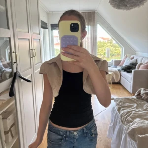 Bolero - Säljer en bolero från Jomar Moda. Boleron har korta ärmar, krage och är tillverkad i ett glansigt material som känns lyxigt. Perfekt att slänga över en topp för en cool och trendig look.