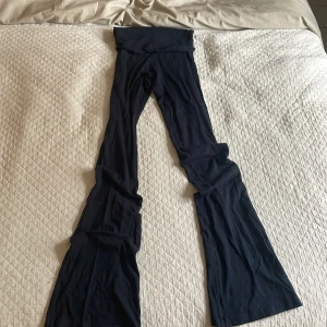 Marinblå  Yogapants  - Säljer ett par svarta byxor med hög midja och riktigt utsvängda ben. Mjukt och stretchigt material som sitter skönt på kroppen. Perfekta för dig som gillar en trendig och bekväm look.
