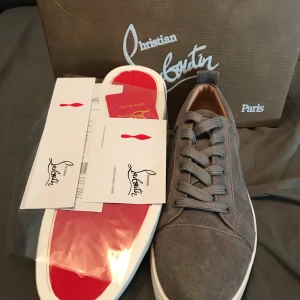 Grå sneakers från Christian Louboutin - grå sneakers från Christian Louboutin med den ikoniska röda sulan. Köptes för ett tag sedan här på plick men inte kommit till andvändning, Hör av er vid frågor pris kan diskuteras, helt nya endast andvända en gång (inga skador eller defekter)