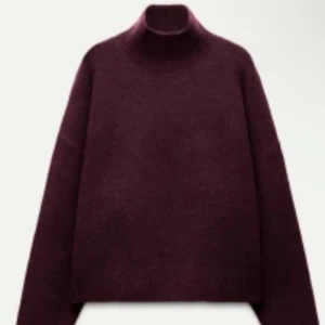 Vinröd polotröja i stickad ull - Snygg vinröd polotröja med hög krage och långärmad design. 