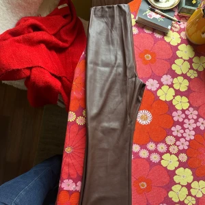 Bruna ”skinn”byxor från Soaked - Snygga bruna byxor i skinnimitation från Soaked in Luxury. De har hög midja med resår och raka ben.