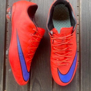 Nike mercurial x - Nike mercurial x (10) retro fotbollsskor i den orange blåa färgen. Skorna är i gott skick. Skriv om ni har några funderingar!