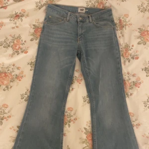 Low Bootcut jeans i ljusblå denim från 157 - Snygga bootcut jeans i ljusblå denim från 157 i storlek M length short. Klassisk femficksmodell med låg midja, bälteshällor och dragkedja. Jeansen har en utsvängd passform nertill och är tillverkade i bomullsmaterial för en bekväm känsla.