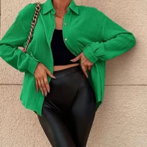 Grön oversized skjorta i bomull - Snygg grön skjorta i oversized modell med klassisk krage och knäppning framtill. Skjortan är tillverkad i ett mjukt, strukturerat bomullstyg och har långa ärmar med manschett. Perfekt att styla lager på lager för en trendig look.