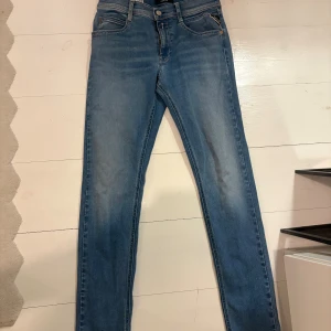 Blå skinny jeans från Replay - Snygga blå skinny jeans från Replay med klassisk femficksdesign och Replay-logga på fickan. Jeansen har en smal passform, normal midja och är tillverkade i stretchigt denim för extra komfort. Perfekta för dig som gillar en stilren och modern look. OBS!  Jeansen är för barn. 158-164 cm. Nytt pris, strax över 1000kr