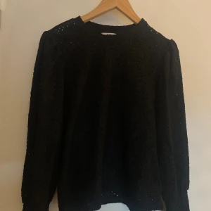 Svart spetsblus - Säljer en svart blus från Object i storlek M. Blusen har lång ärm och är helt täckt av broderad spets med fina hålmönster. Rund halsringning och lätt puff vid axlarna. Den är använd därav nedsatt pris men inga större defekter💕