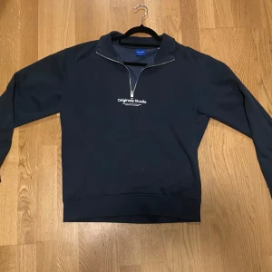 Mörkgrön Halv Zip Originals Studio - Snygg och fräsch mörkgrön sweatshirt från Jack & Jones Originals Studio.