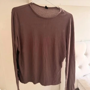 Brun långärmad basic tröja - En enkel brun långärmad tröja med rund halsringning. Tröjan är ribbad och har en slim passform som sitter snyggt på kroppen. Perfekt att styla med jeans eller kjol för en clean look. Fel storlek för mig 
