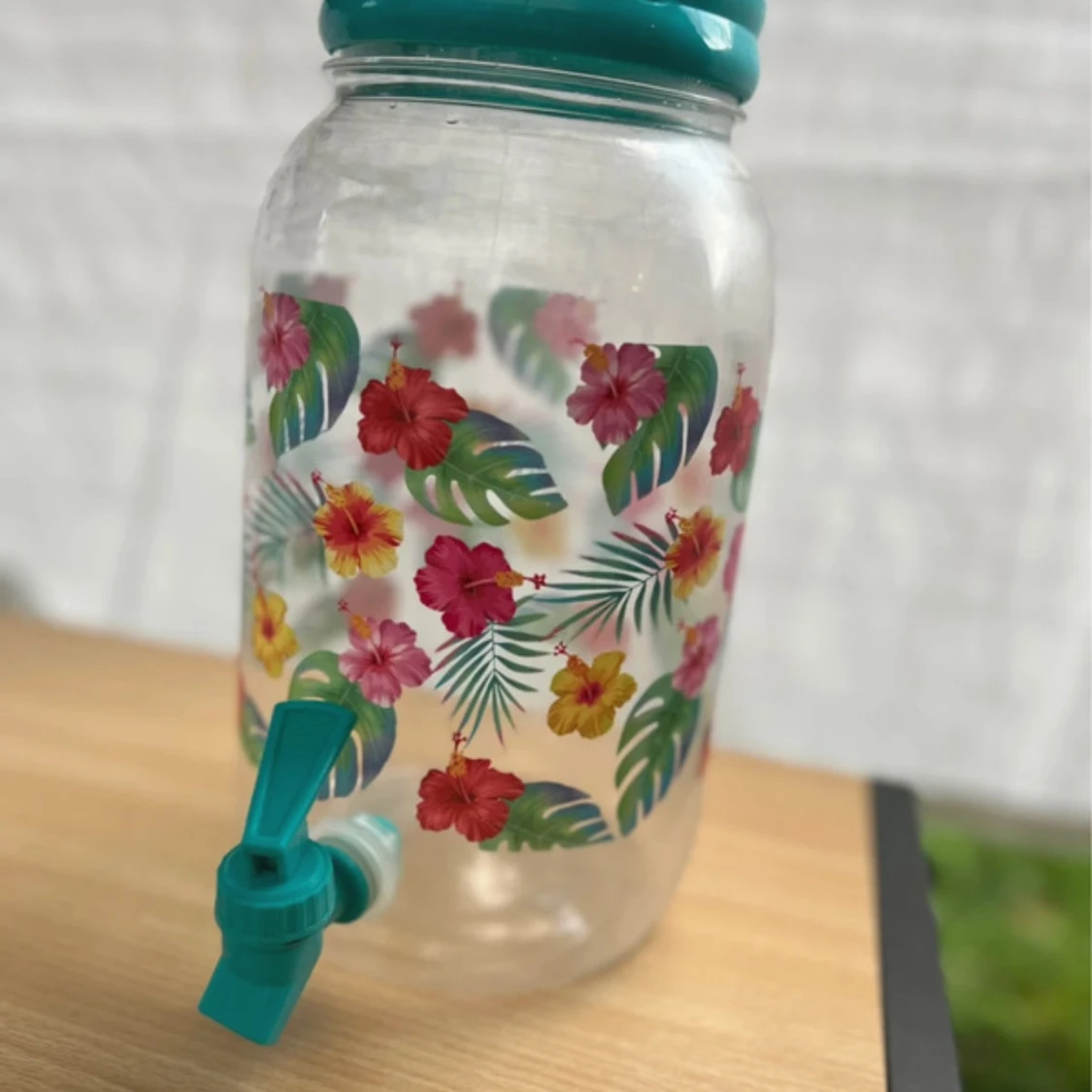 Blommig dryckesbehållare med kran