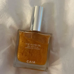 CAIA The Glow Oil - Säljer en CAIA The Glow Oil, en skimrande kroppsolja med guldigt skimmer. Oljan innehåller avokadoolja och vitamin E. Oanvänd. 