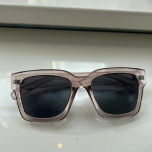 Transparenta solglasögon  - Snygga solglasögon med transparent, fyrkantig båge och mörka glas. 