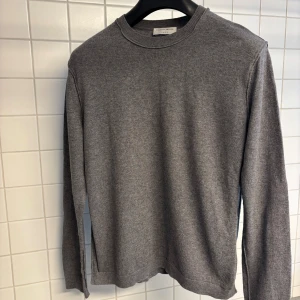 Stickad tröja från Tiger - Stickad tröja 55% Merinoull och 45% Bomull. Sparsamt använd i gott skick. 