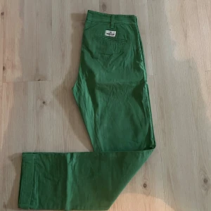 Gröna chinos från Morris - Snygga gröna chinos från Morris med klassisk passform och raka ben. Byxorna har bälteshällor, knappstängning och fickor både fram och bak. Tillverkade i mjuk bomull som är skön mot huden. Perfekt för dig som vill sticka ut med färg. Pris kan diskuteras. W32 L33