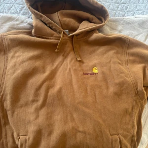Brun hoodiejacka från Carhartt L - Säljer en brun hoodiejacka från Carhartt Work In Progress i storlek L. Jackan har huva, broderad logga på bröstet och är tillverkad i mjuk bomull. Perfekt för dig som gillar streetwear och vill ha en chill look med långärmad passform.