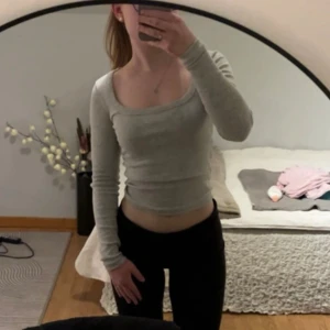Tröja från Nelly  - Säljer en ljusgrå långärmad tröja med tight passform och rundad, något djupare halsringning. Tröjan är i storlek xxs o kommer ifrån Nelly 