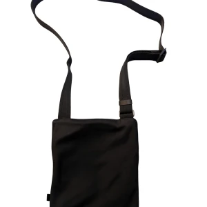 Svart axelväska från BOSS - Snygg svart axelväska från BOSS med justerbar rem och dragkedja framtill. Väskan har ett stilrent tryck med BOSS-loggan i gult och vitt samt ett rymligt huvudfack. Tillverkad i slitstark polyester, perfekt för att bära dina viktigaste grejer.