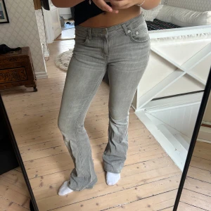 Grå bootcut jeans med låg midja - Snygga grå jeans med bootcut och låg midja. Jeansen har klassisk femficksdesign och är i ett mjukt denimtyg som sitter skönt. 