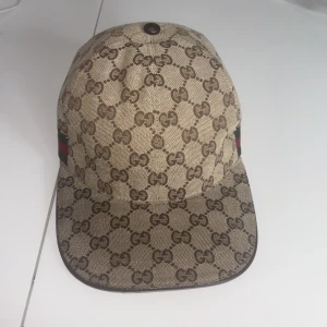 Beige Gucci Keps med GG-Mönster - Detta är en Gucci keps som passar bra nästan till alla stilar. Jag säljer den nu för att jag ska köpa nåt annat för pengarna. Skriv om du är intresserad!