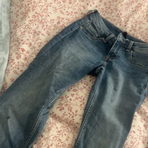 Blå bootcut jeans från hm - Säljer ett par klassiska blå hm byxor med bootcut passform. Jeansen har fem fickor, bälteshällor och dragkedja med knapp. Materialet är slitstarkt denim och färgen är ljusblå med snygga tvättade detaljer. Perfekt för dig som gillar retrostil.