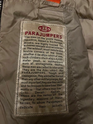 Svart dunjacka från Parajumpers - Säljer en svart dunjacka från Parajumpers med huva och snyggt broderat märke på ärmen. Jackan har quiltad design, dragkedja framtill och beige insida. Perfekt för kalla dagar och har en clean, sportig look. Använd längre, därför säljer så billigt. Den är äkta, köpt för 3999:-