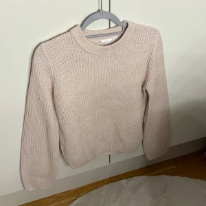 Beige stickad tröja från Kappahl sitter som xs - Säljer en beige stickad tröja  i storlek 164. Tröjan har en klassisk rund halsringning och är ribbstickad med långa ärmar. Perfekt för dig som gillar en enkel och clean look med mjukt material.