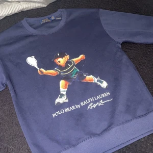 Mörkblå Polo Bear tröja Ralph Lauren - Polo Bear crewneck 	•	Storlek M 	•	Helt ny/oanvänd 	•	Mörkblå 	•	Tennis-björnen på framsidan     