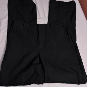 Kostymbyxor - Högmidjade Bootcut kostymbyxor från BikBok i storlek 40. Jeansen är använda några gånger men inga större tecken på användning.